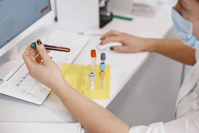 A lab worker labelling blood samples at her desk